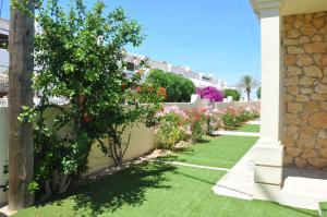 un jardín con flores al lado de una casa en Chalet Las Rosas, en Denia