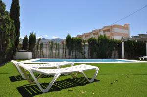 un sillón blanco junto a la piscina en Chalet Las Rosas, en Denia