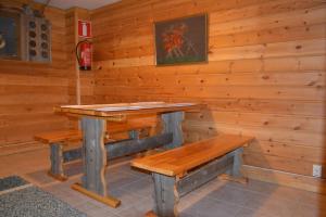 a wooden room with a wooden table and benches at Tenon Eräkievari in Karigasniemi
