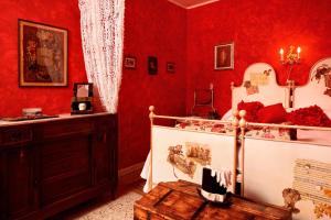 a bedroom with red walls and a bed with a wooden table at C'era una Volta in Perledo