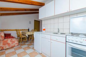 a kitchen with white appliances and a dining room with a table at Apartments Bilo in Primošten