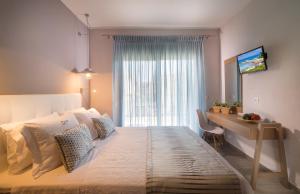 ネオス・マルマラスにあるParadise Maisonettesのベッドルーム1室(ベッド1台、デスク、窓付)