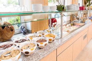 a buffet with many bowls of food on a counter at Hotel Bavaria in Dingolfing