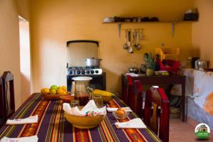 una cocina con una mesa con tazones de fruta. en Loma Wasi Alojamiento Rural Indígena en Cotacachi, en Cotacachi