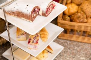 a display case with different types of bread and pastries at Hotel Bavaria in Dingolfing +116 photos