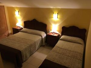 pokój hotelowy z 2 łóżkami i oświetleniem na ścianie w obiekcie La Badia w mieście Sant Felíu de Pallarols