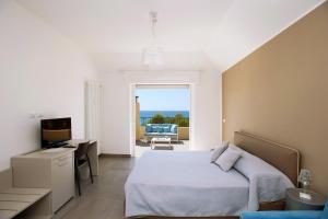 a bedroom with a bed and a desk and a television at B&B Ligure Rooms in Pietra Ligure