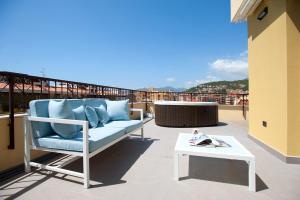 a blue couch on a balcony with a table at B&B Ligure Rooms in Pietra Ligure
