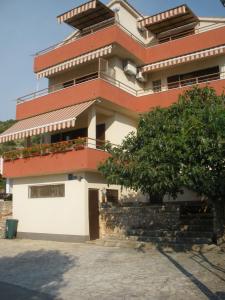 a building with a tree in front of it at Apartments Bilo in Primošten