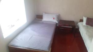 a small room with two beds and a table at Sembuwatta Reach Homestay in Elkaduwa