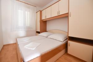 a small bedroom with a bed and cabinets at Milka Appartements in Stara Novalja