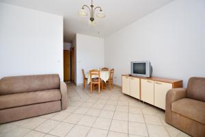 a living room with a couch and a tv at Milka Appartements in Stara Novalja
