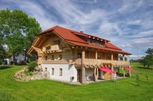 une grande maison en bois avec un toit rouge dans l'établissement Holzhaus Lugerhof, à Roding