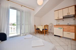 a kitchen and dining room with a table and a window at Milka Appartements in Stara Novalja