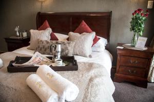 a hotel room with a bed with a tray of food on it at Arista Guesthouse in Bloemfontein