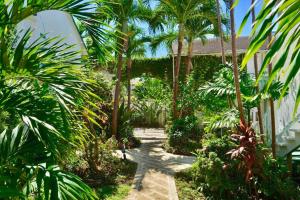 a garden with palm trees and a pathway at Cobblers Cove - Barbados in Saint Peter