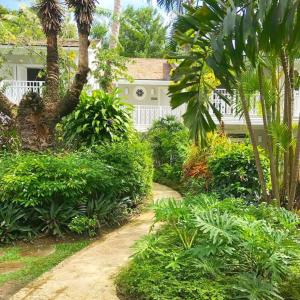 a garden in front of a house with trees and bushes at Cobblers Cove - Barbados in Saint Peter