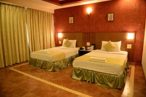Goa Woodlands Hotel في مادغاون: غرفه فندقيه سريرين في غرفه