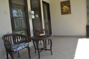a room with two chairs and a table and a stool at Pondok Bali Sea View Bungalow in Lovina