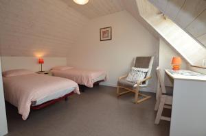 a bedroom with two beds and a desk and a chair at Chambres d'hôtes La Fontaine Garel in Iffendic