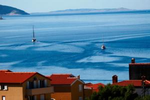 two boats floating in the water near a city at Hotel Zlatni Lav in Martinšćica