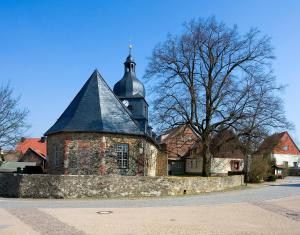 an old brick building with a black roof at Ferienwohnung Stiem in Dankerode