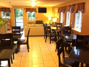 a restaurant with tables and chairs and a couch at King Oscar Motel Centralia in Centralia