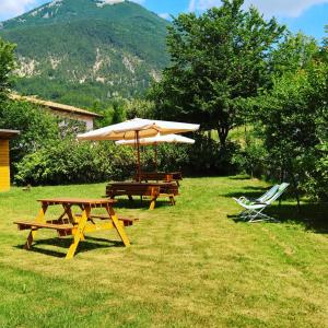 a picnic table and an umbrella and chairs in the grass at Da Nonna Li Rooms and Breakfast in Villetta Barrea