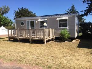 a tiny house with a porch and a deck at Camping Barataud in Saint-Denis-dʼOléron