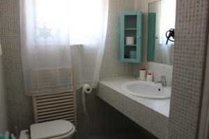 a bathroom with a sink and a toilet and a mirror at B&B Pizzo Cannicchio in Matera