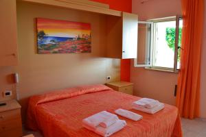 a bedroom with a bed with two towels on it at Villaggio Calispera in Capo Vaticano +56 photos