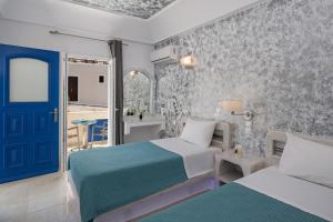 1 dormitorio con 2 camas y puerta azul en Phoenix en Fira
