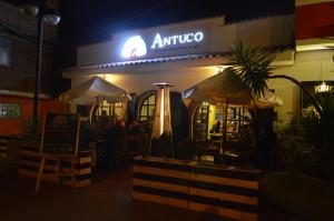 a restaurant with an umbrella and people sitting outside at night at Amelita Hotel Boutique in Huaraz
