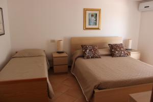 a bedroom with two beds and two night stands at B&B Pizzo Cannicchio in Matera
