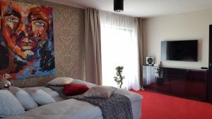a living room with a white couch and a painting at Axel Boutique Jacuzzi & Sauna in Dziwnów
