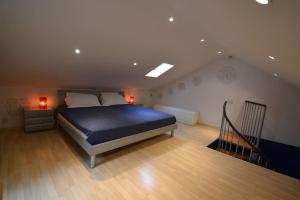 a bedroom with a blue bed and a staircase at Maisonnette in Liège