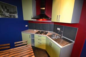 uma pequena cozinha com um lavatório e um fogão em Maisonnette em Liège