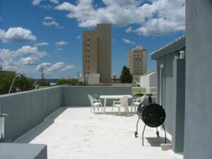 a patio with a table and chairs on a roof at Al Mar Departamentos in Puerto Madryn