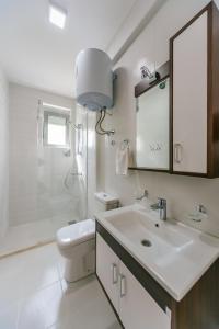 a bathroom with a sink and a toilet and a mirror at Teuta Apartments in Ulcinj +70 photos