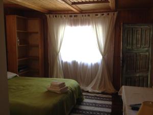 a bedroom with a green bed and a window at Fisherman's Cottage in Cacica