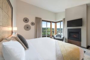 a bedroom with a large bed and a fireplace at Friday Harbor House in Friday Harbor