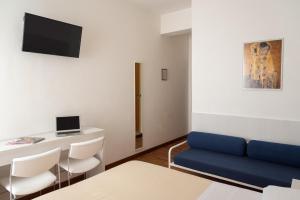 uma sala de estar com um sofá azul e uma mesa em Hotel Nettuno em Pesaro