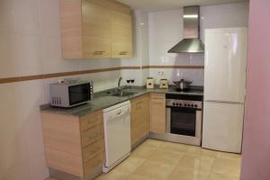 a kitchen with a white refrigerator and a microwave at Residencial Algaida in Oropesa del Mar