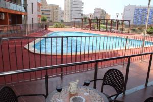 a balcony with a table and a swimming pool at Residencial Algaida in Oropesa del Mar