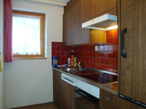サース・アルマゲルにあるAzurの赤いタイル張りの壁、シンク付きのキッチンが備わります。