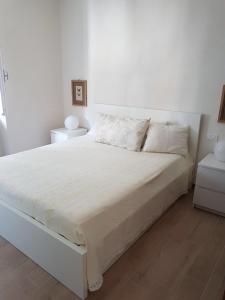ラ・スペツィアにあるSky Apartmentの白い壁のベッドルームの白いベッド1台