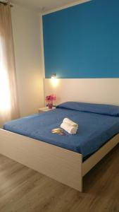 a bedroom with a bed with a blue wall at Hotel Ogliastra in Lotzorai
