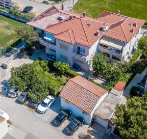an overhead view of a house with cars parked in a parking lot at Apartaments Oma & Opa in Rab