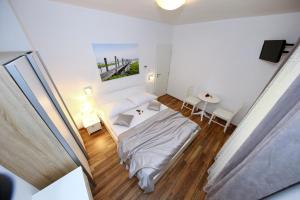 a bedroom with a bed and a table and chairs at Apartments Maruna Self check-in in Zadar