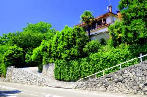 una casa al lado de una colina con árboles en Guest House Lifestyle Holiday, en Opatija